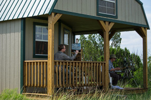 Pete Quaid and Steve Miller painting on porch of cabin overlooking the Pease River
